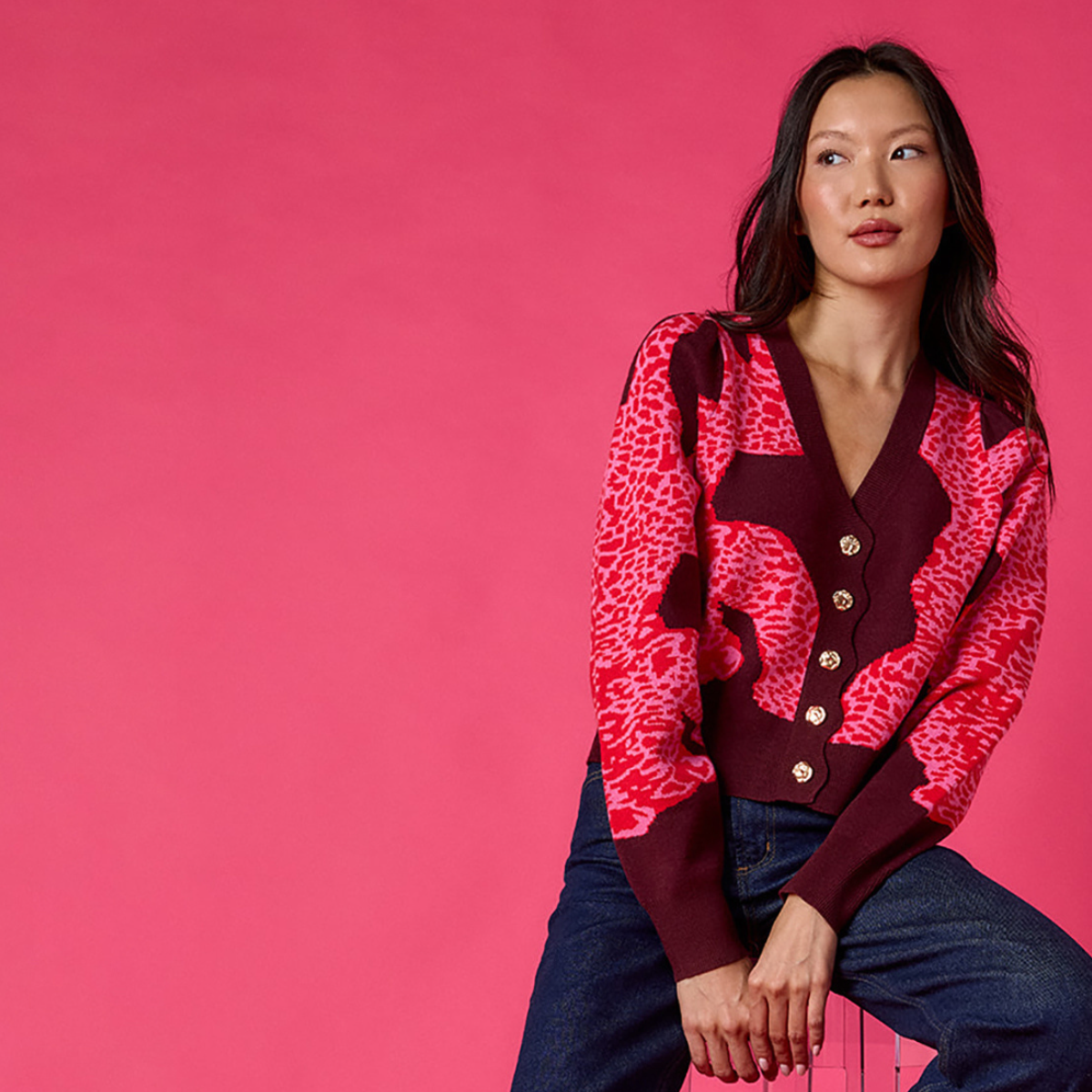 woman wearing pink sweater on a pink background.