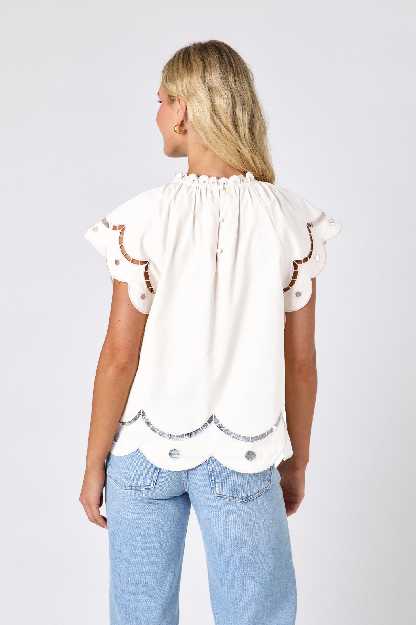 Cream raglan style short sleeve top with fagoting and scallop details on model — CROSBY by Mollie Burch