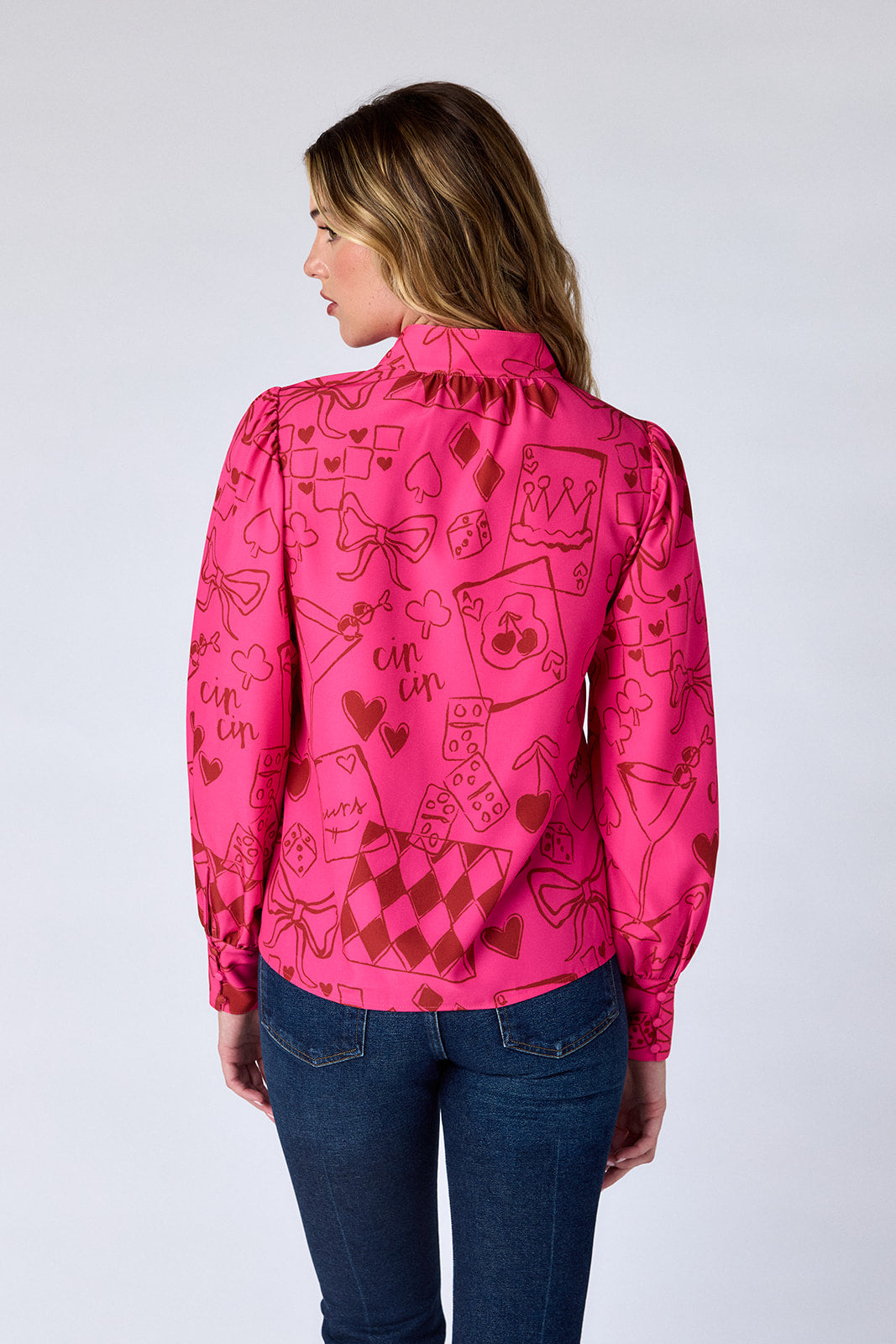 Woman wearing a pink patterned shirt with a white background