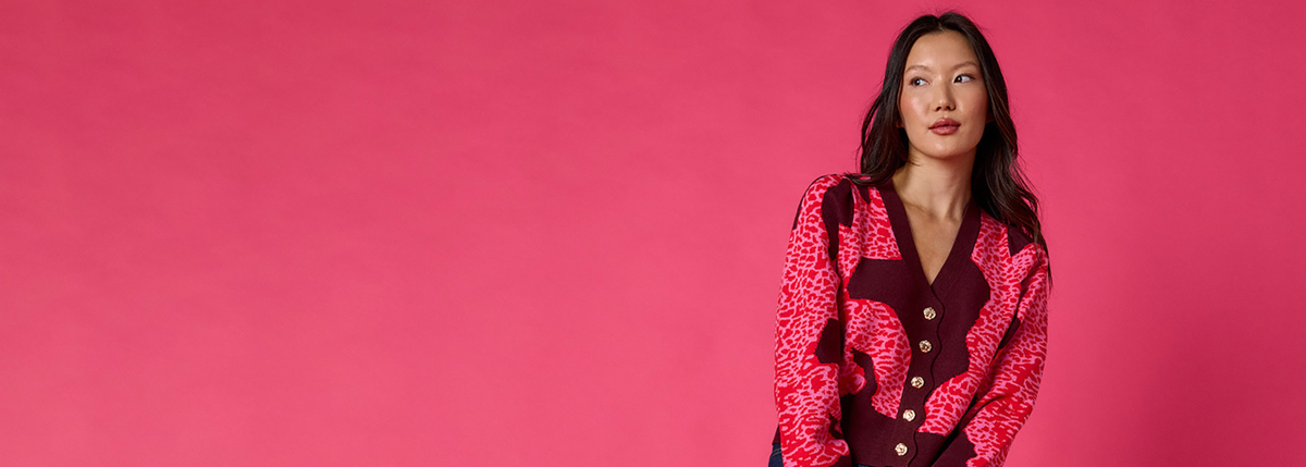 woman wearing pink sweater on a pink background.