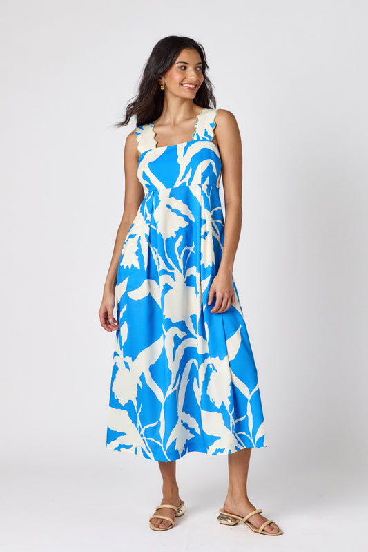 Blue Fern midi dress with fitted bodice and wavy straps on model — CROSBY by Mollie Burch