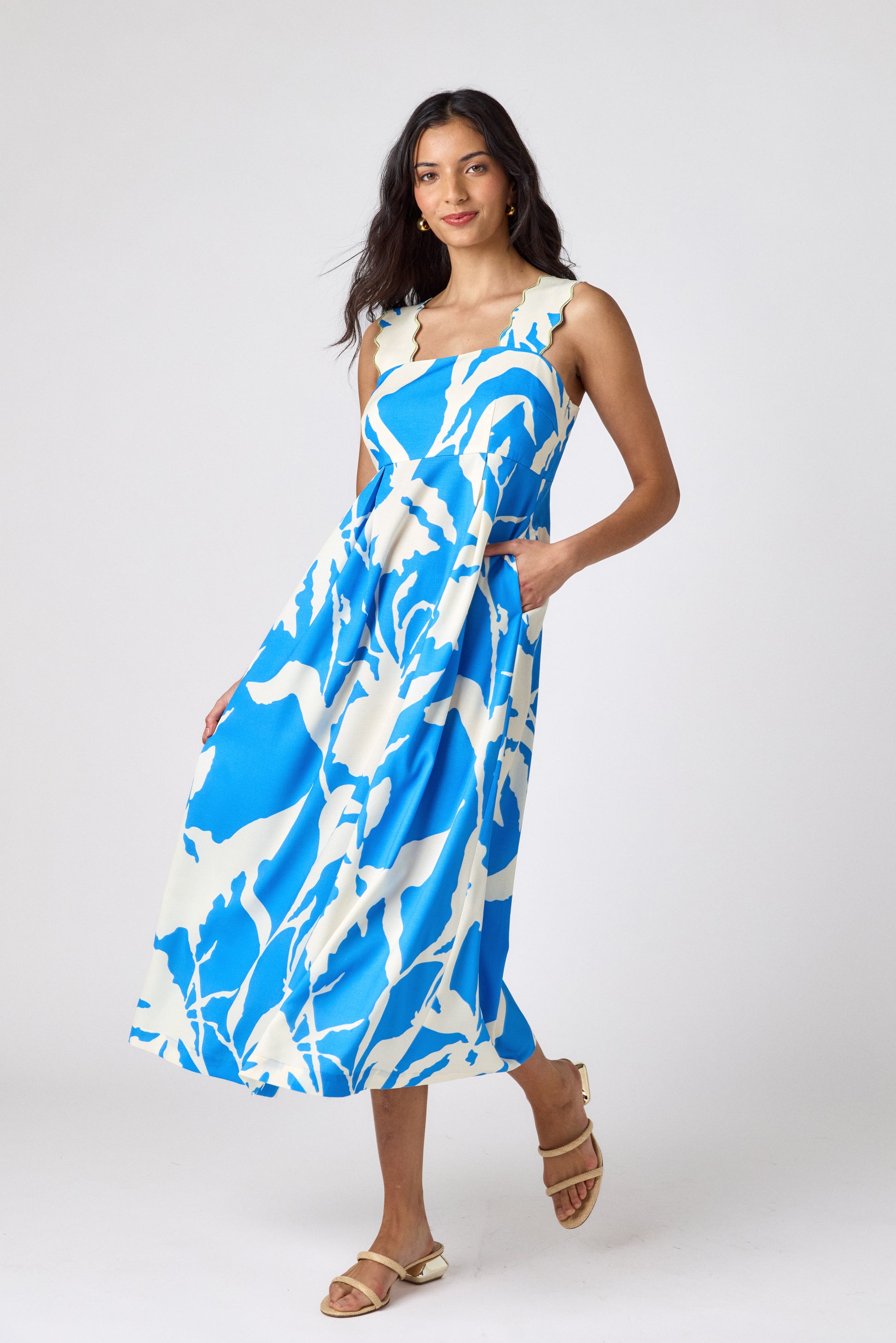 Blue Fern midi dress with fitted bodice and wavy straps on model — CROSBY by Mollie Burch