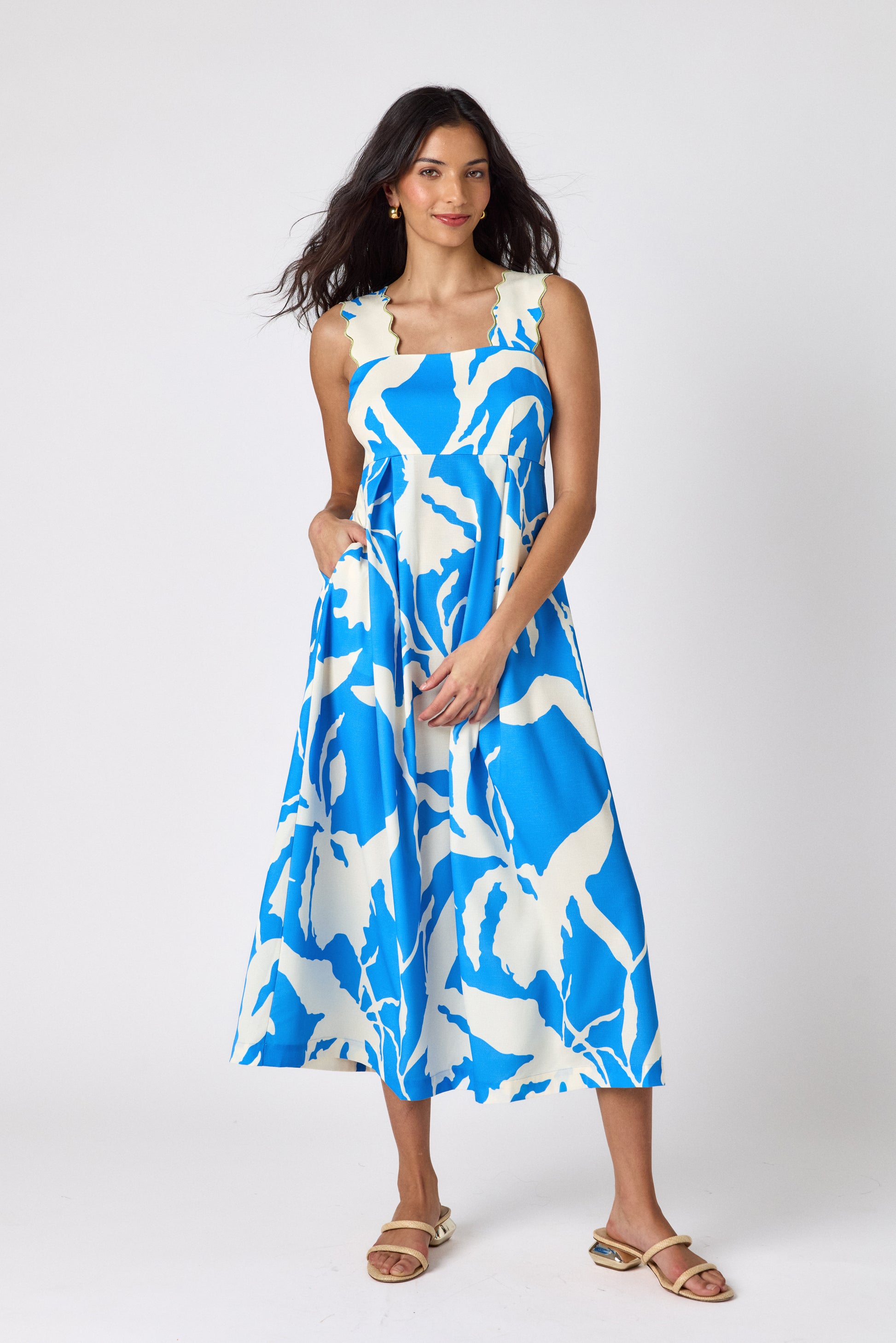 Blue Fern midi dress with fitted bodice and wavy straps on model — CROSBY by Mollie Burch