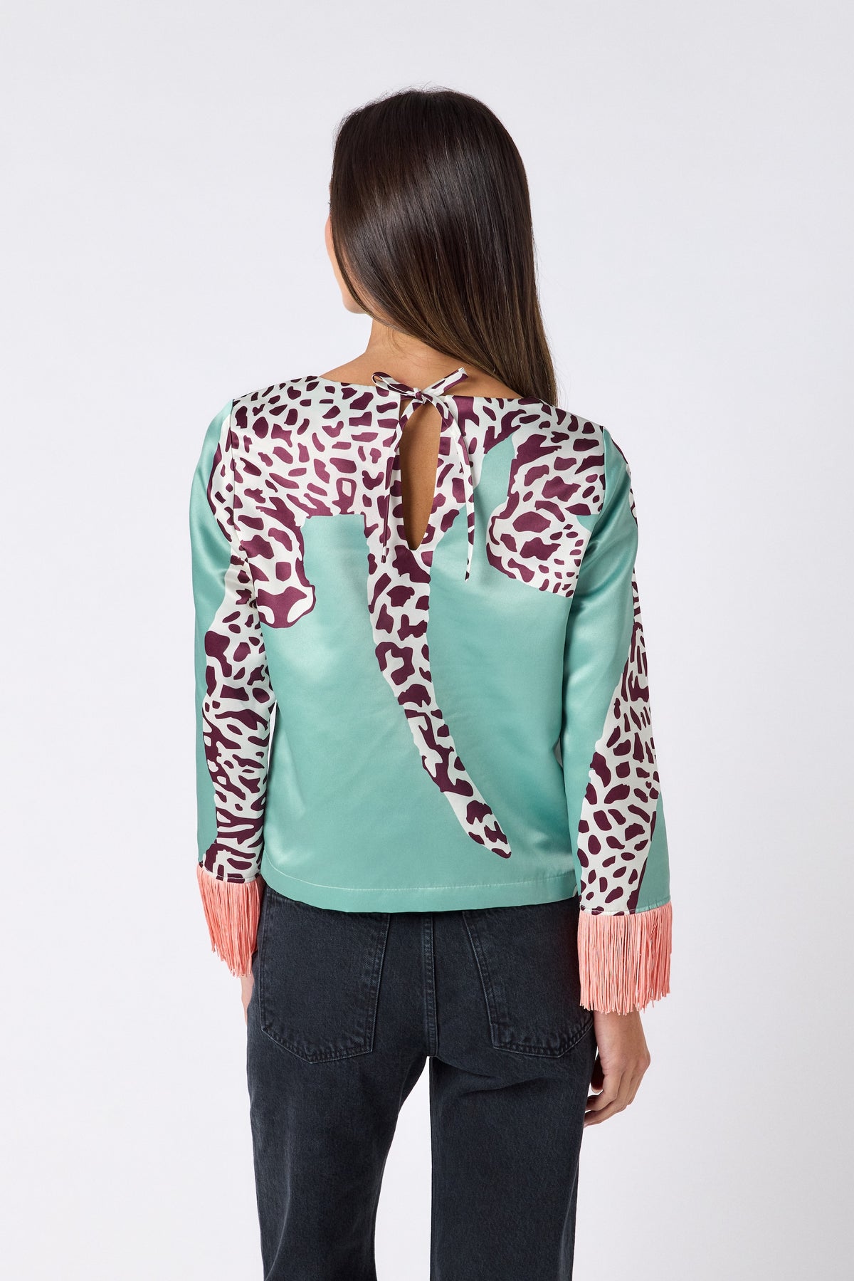 Maya Top in Mint Catwalk featuring contrast fringe sleeve cuffs and back neck tie detailing on model – CROSBY by Mollie Burch