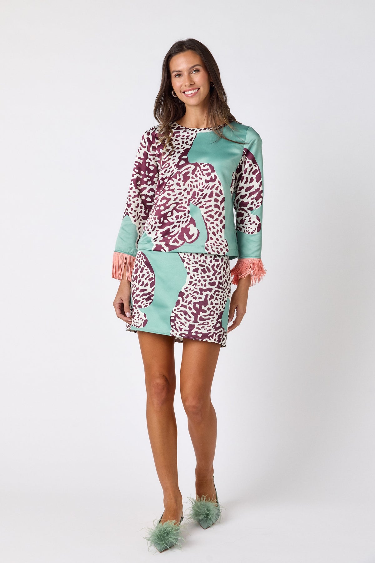 Penny Mini Skirt in Mint Catwalk featuring a bold animal-inspired print on model – CROSBY by Mollie Burch
