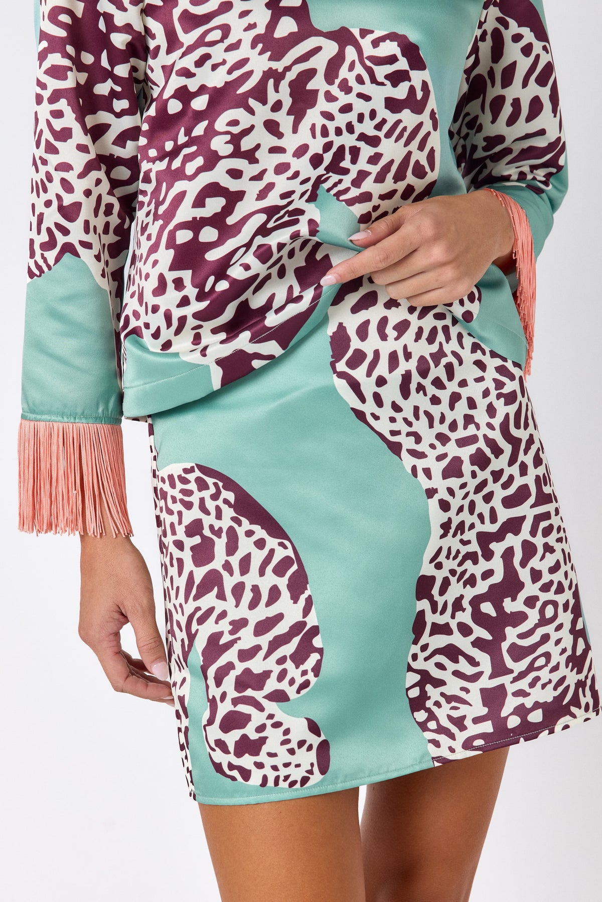 Penny Mini Skirt in Mint Catwalk featuring a bold animal-inspired print on model – CROSBY by Mollie Burch