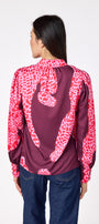Leland Blouse in Pink Catwalk featuring puff sleeves and gold-rimmed buttons on model – CROSBY by Mollie Burch
