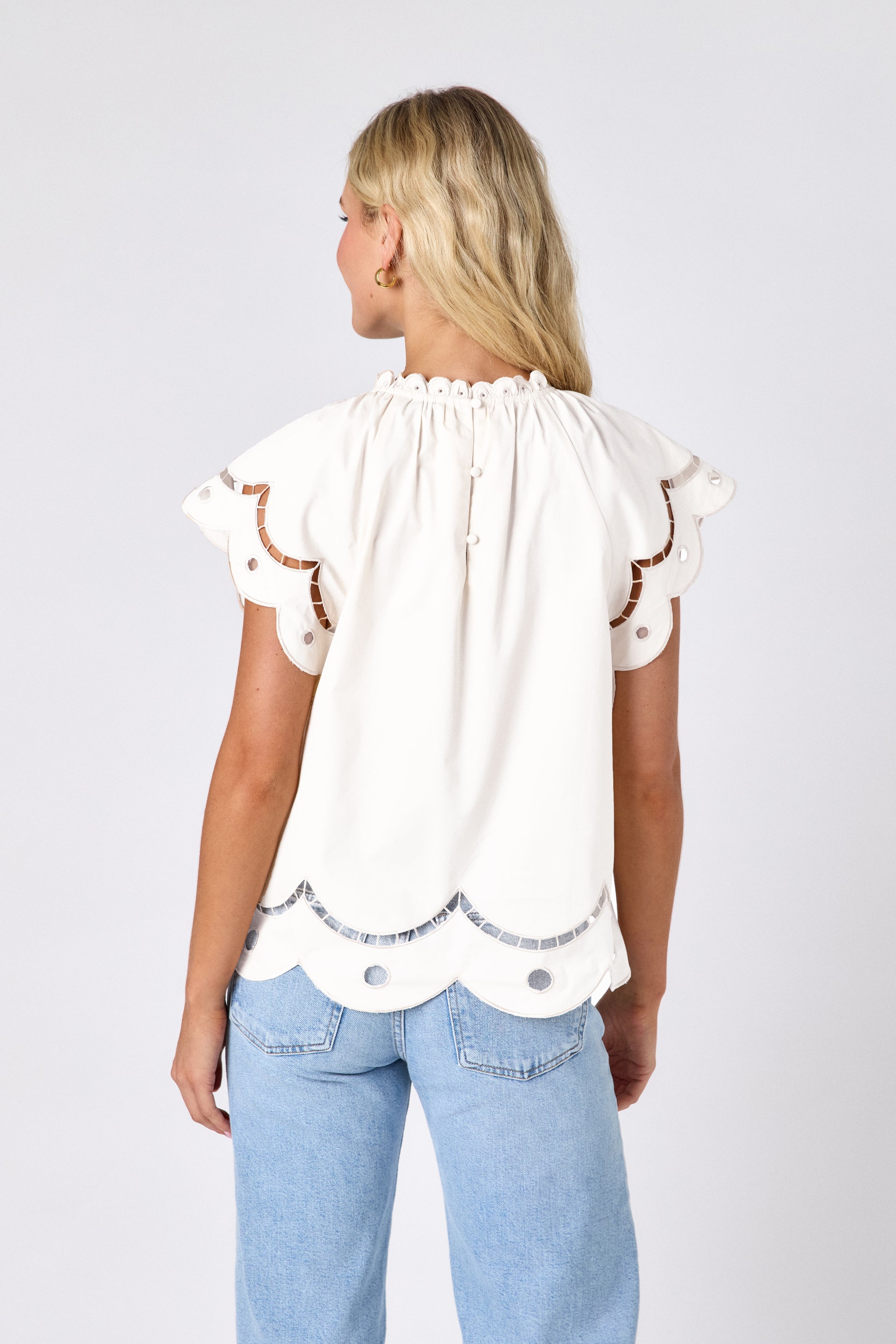 Cream raglan style short sleeve top with fagoting and scallop details on model — CROSBY by Mollie Burch