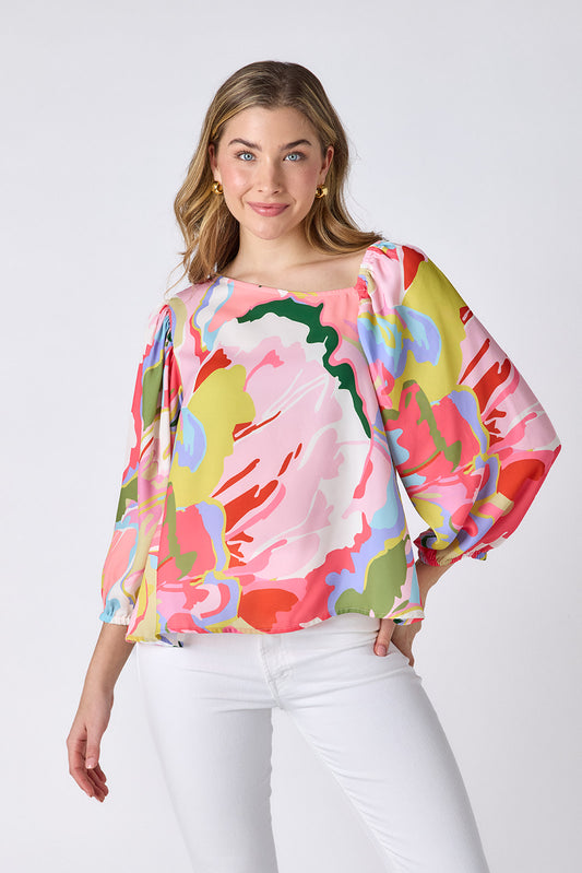 Flutter 3/4 sleeve top with asymmetrical neckline on model — CROSBY by Mollie Burch