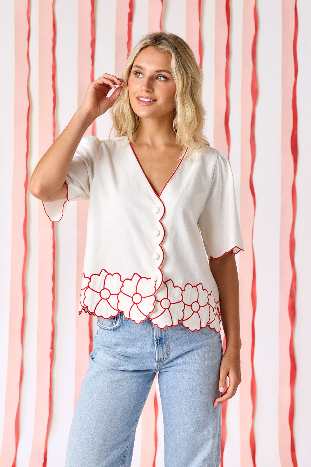 Ivory short sleeve buttondown top with scalloping and floral appliqué detail on model — CROSBY by Mollie Burch
