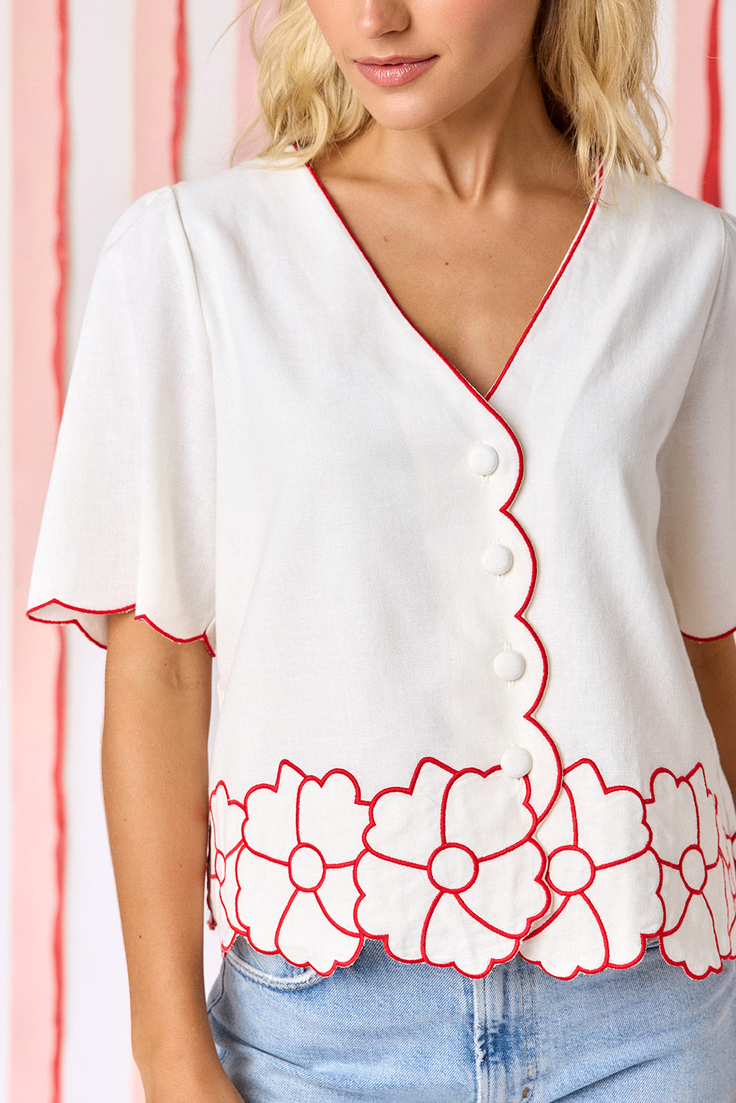 Ivory short sleeve buttondown top with scalloping and floral appliqué detail on model — CROSBY by Mollie Burch