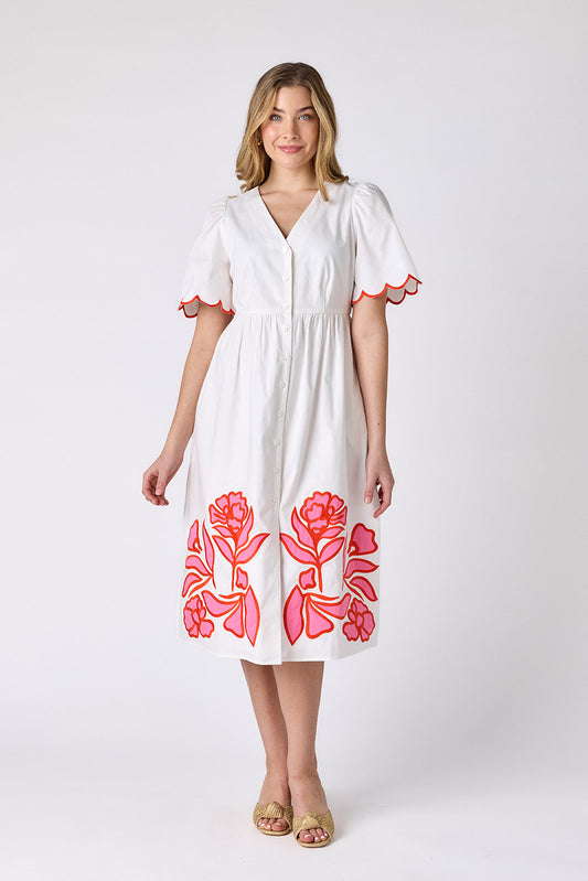 Ivory cotton button-down midi dress with scalloped sleeves and pink and red embroidery on model — CROSBY by Mollie Burch