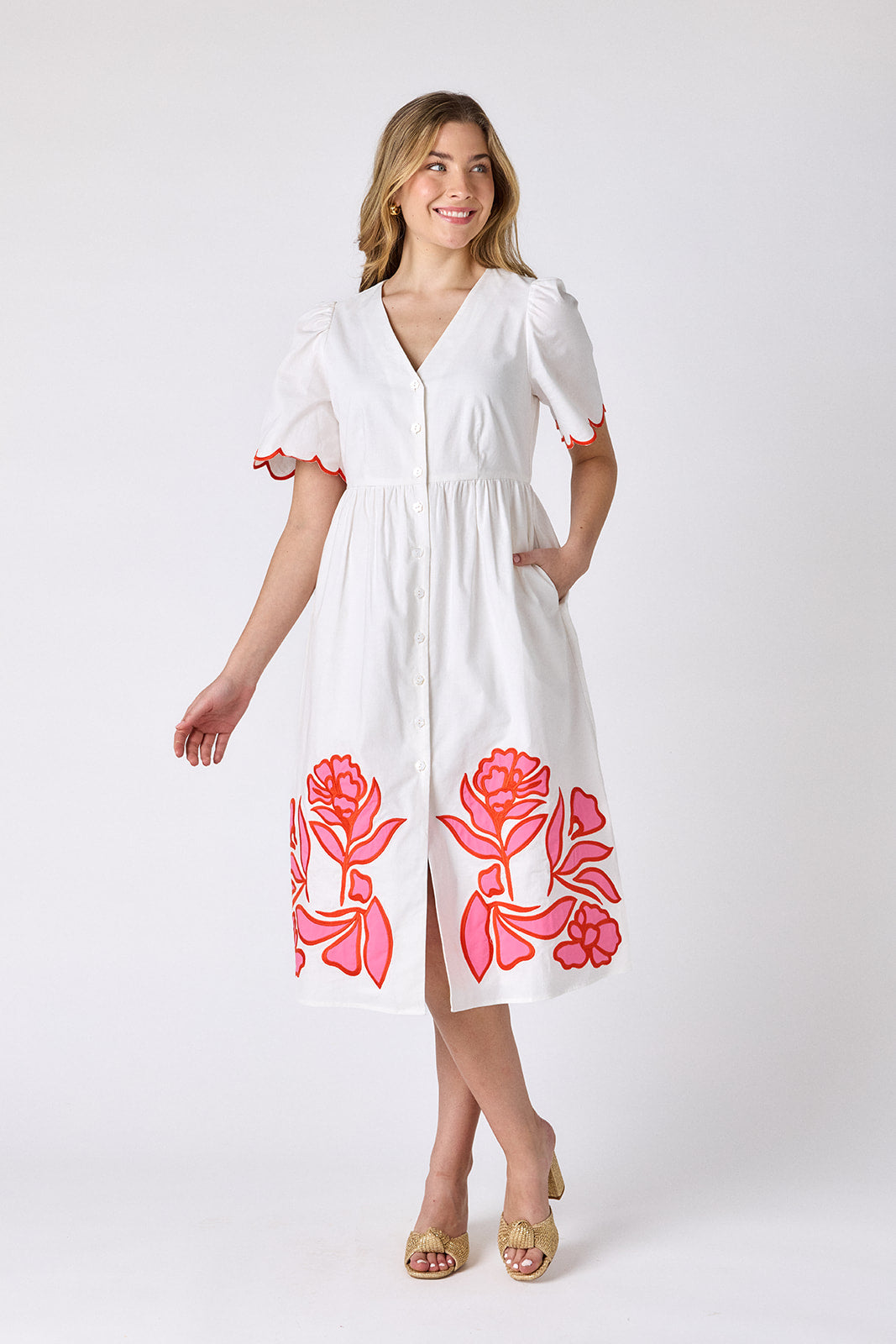 Ivory cotton button-down midi dress with scalloped sleeves and pink and red embroidery on model — CROSBY by Mollie Burch