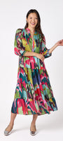 Macrostie Dress in Life of the Party featuring a tiered midi skirt and gold-accented buttons on model – CROSBY by Mollie Burch
