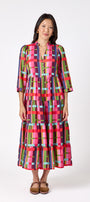 Macrostie Dress in Plaid Parade featuring a colorful plaid print, tiered midi skirt, and gold-accented buttons on model – CROSBY by Mollie Burch