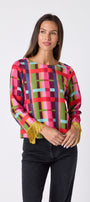 Maya Top in Plaid Parade featuring contrast fringe sleeve cuffs and back neck tie detailing on model – CROSBY by Mollie Burch