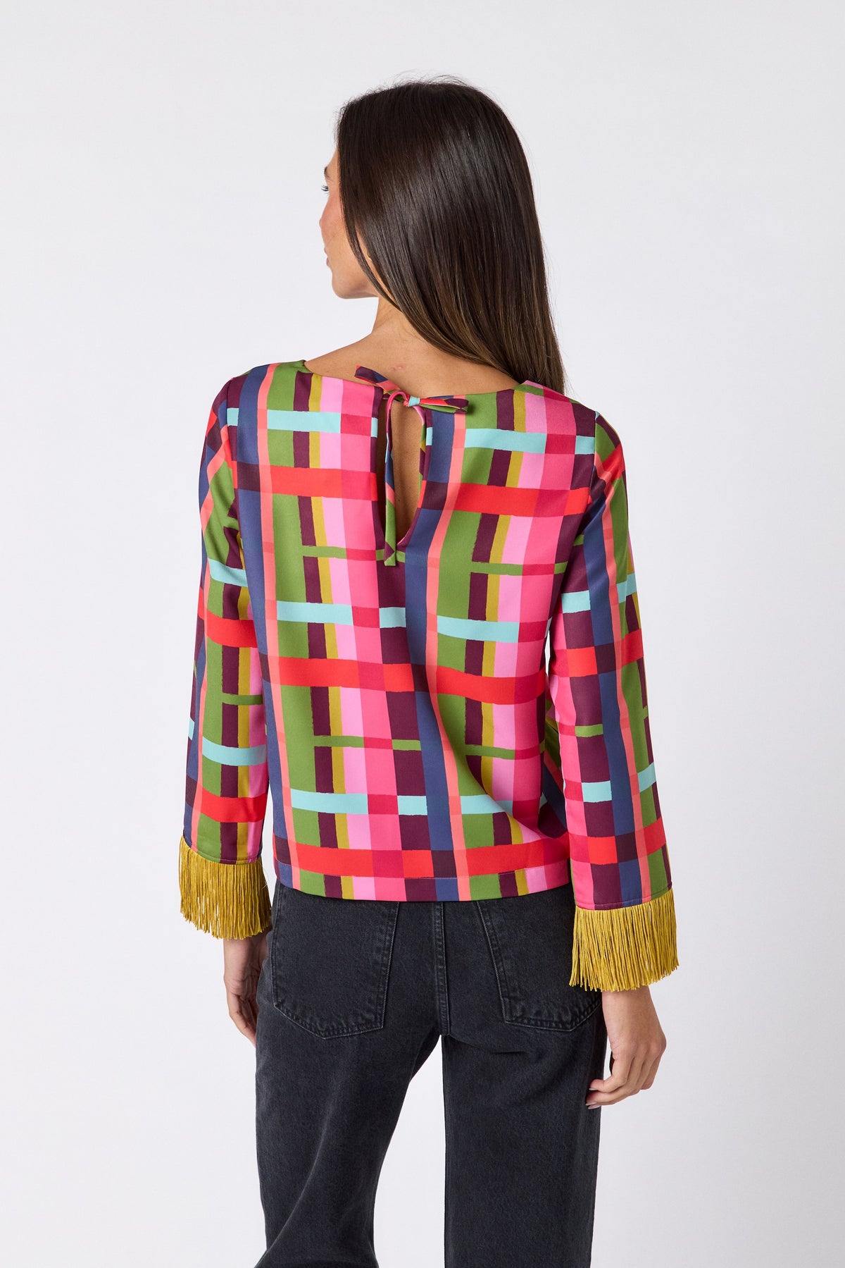 Maya Top in Plaid Parade featuring contrast fringe sleeve cuffs and back neck tie detailing on model – CROSBY by Mollie Burch