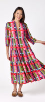 Macrostie Dress in Plaid Parade featuring a colorful plaid print, tiered midi skirt, and gold-accented buttons on model – CROSBY by Mollie Burch