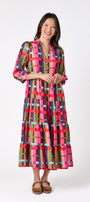 Macrostie Dress in Plaid Parade featuring a colorful plaid print, tiered midi skirt, and gold-accented buttons on model – CROSBY by Mollie Burch