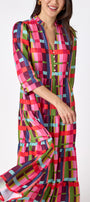 Macrostie Dress in Plaid Parade featuring a colorful plaid print, tiered midi skirt, and gold-accented buttons on model – CROSBY by Mollie Burch
