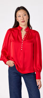 Leland Blouse in Ruby Red featuring puff sleeves and gold-rimmed pearl buttons on model – CROSBY by Mollie Burch
