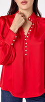 Leland Blouse in Ruby Red featuring puff sleeves and gold-rimmed pearl buttons on model – CROSBY by Mollie Burch