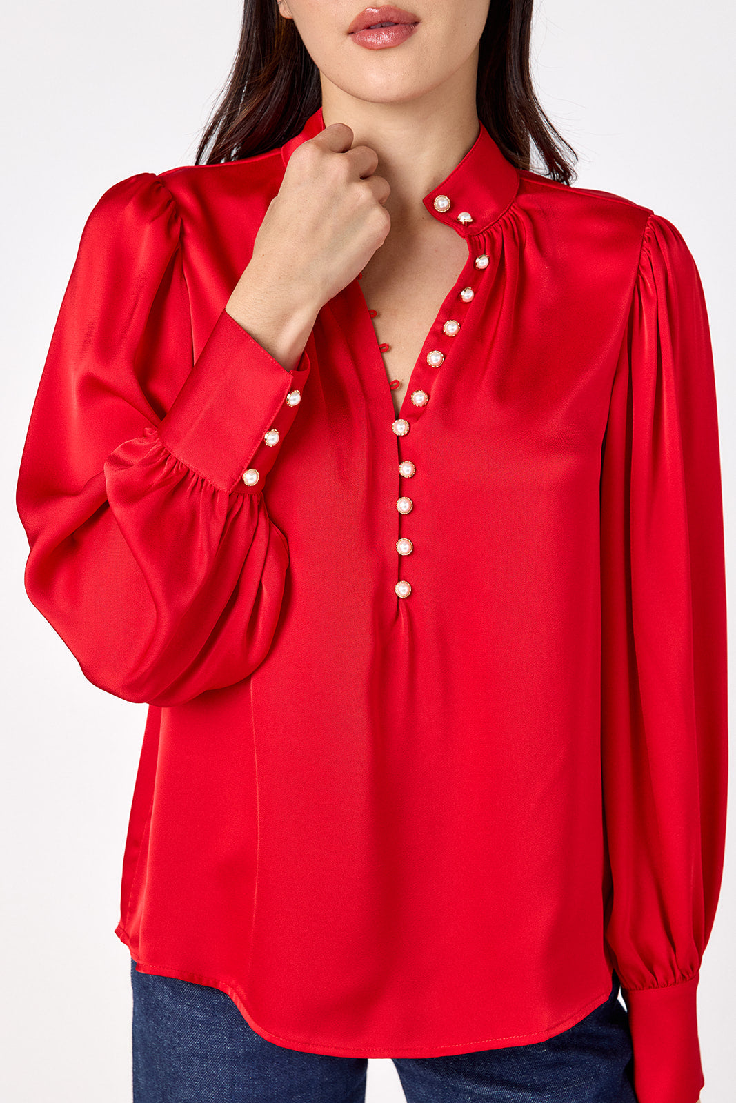 Leland Blouse in Ruby Red featuring puff sleeves and gold-rimmed pearl buttons on model – CROSBY by Mollie Burch