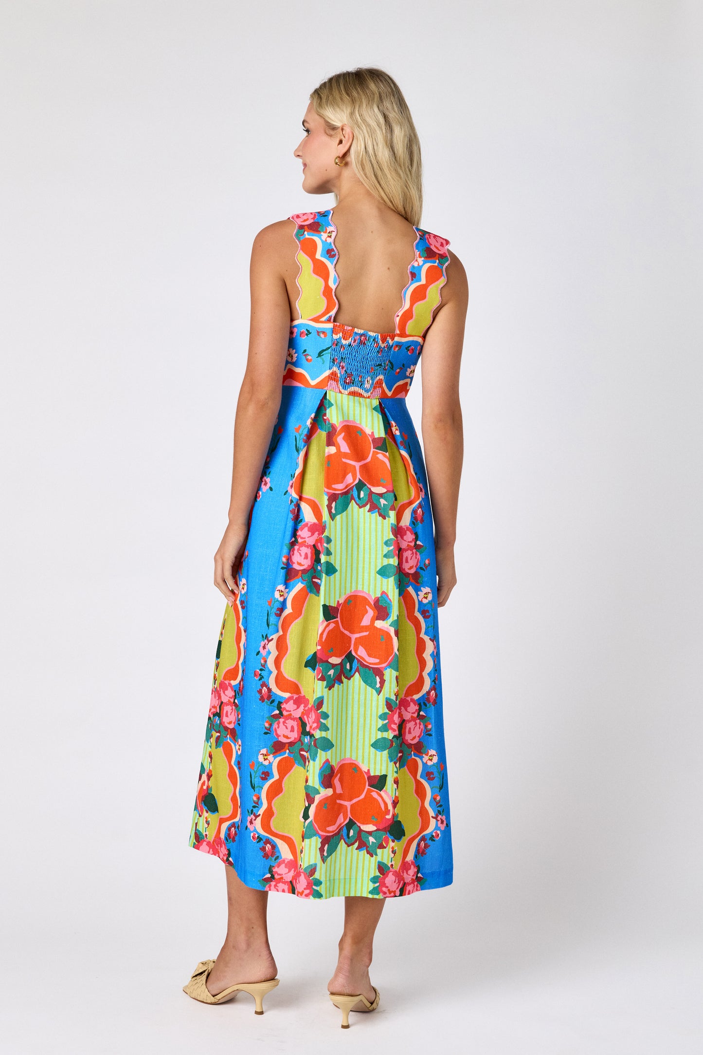 The Grove midi dress with fitted bodice and wavy straps on model — CROSBY by Mollie Burch