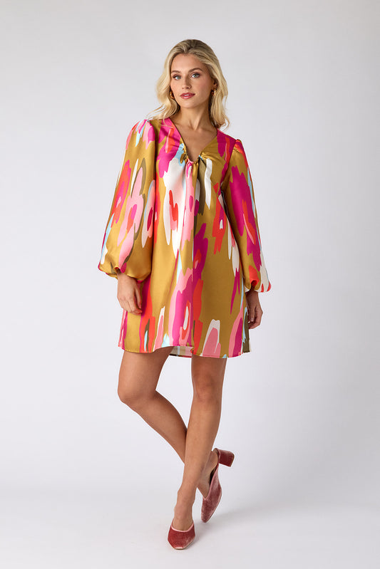 Woman wearing a colorful dress with abstract patterns on a white background