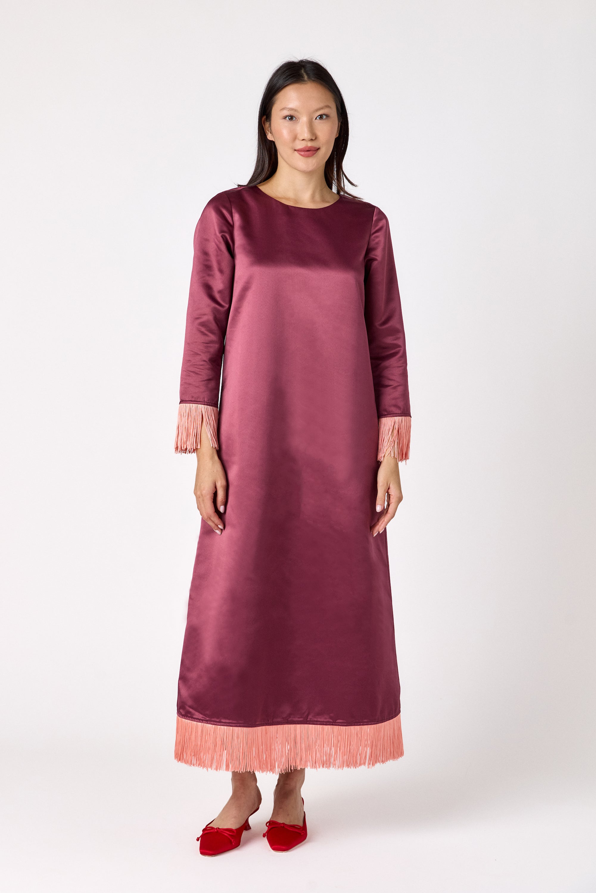 Drewry Dress in Wine featuring satin fabric and contrast fringe trim on model – CROSBY by Mollie Burch