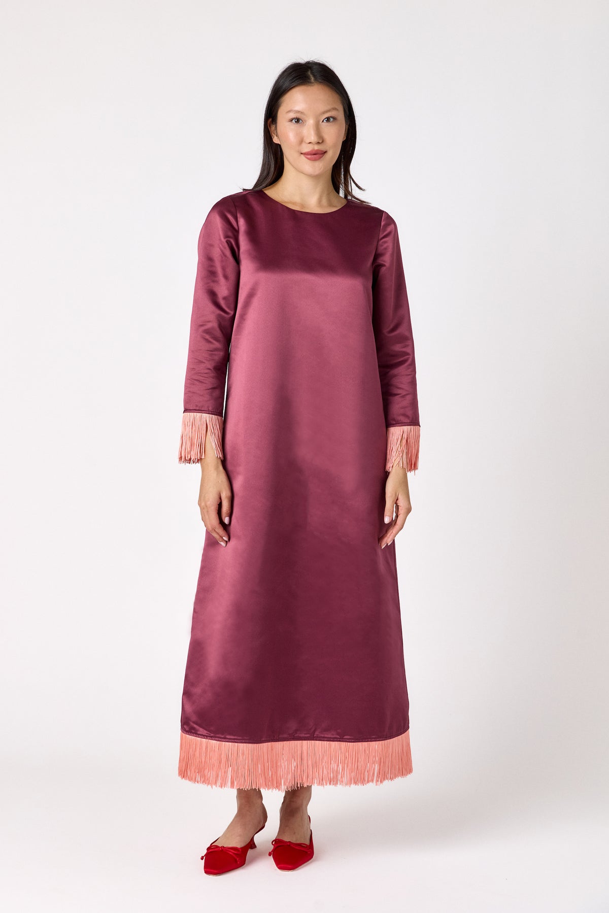 Drewry Dress in Wine featuring satin fabric and contrast fringe trim on model – CROSBY by Mollie Burch