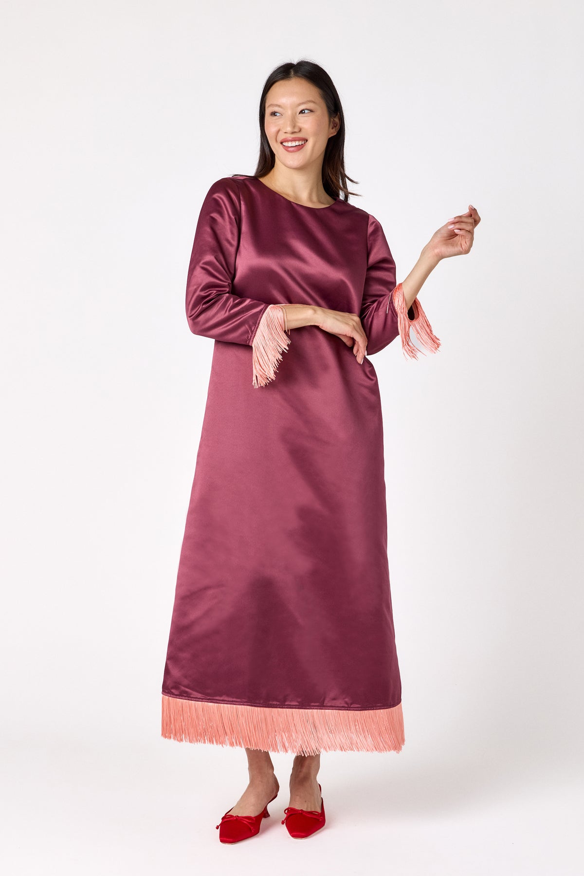 Drewry Dress in Wine featuring satin fabric and contrast fringe trim on model – CROSBY by Mollie Burch