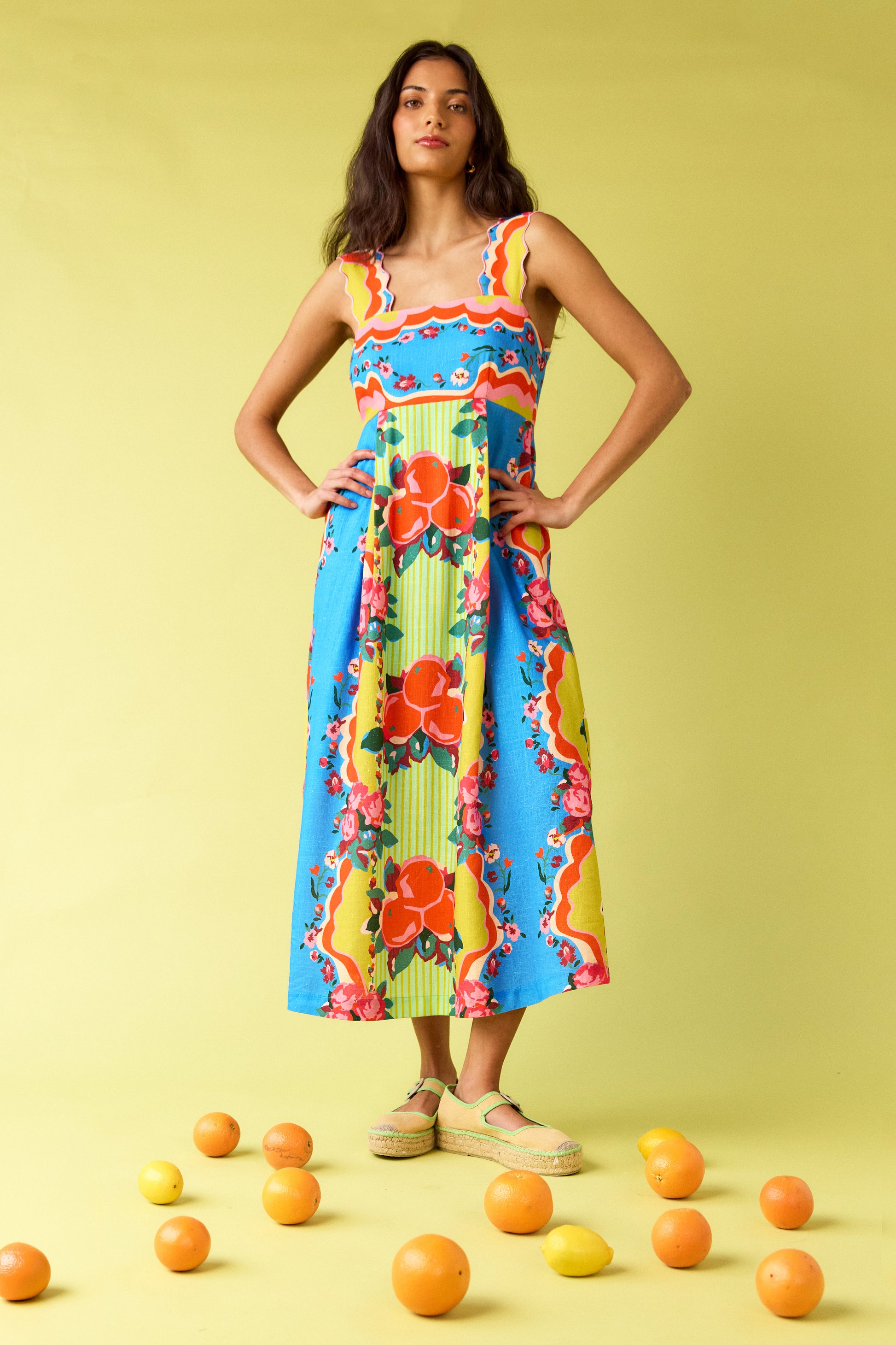 The Grove midi dress with fitted bodice and wavy straps on model — CROSBY by Mollie Burch