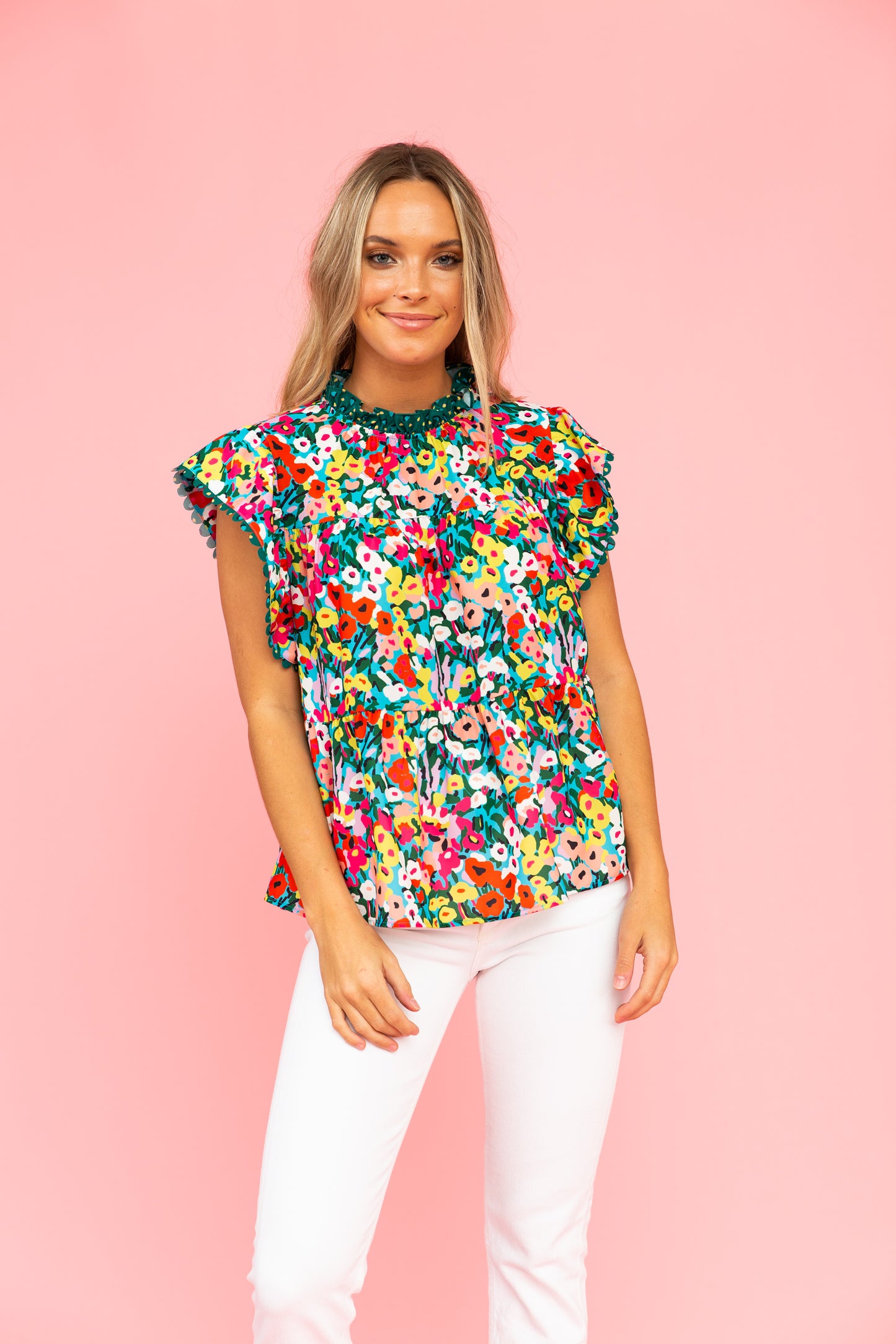Brightly colored floral top with tiered silhouette and white jeans