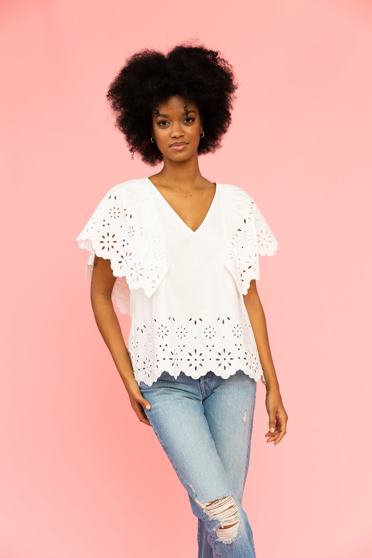 White v-neck top with broderie details and distressed jeans