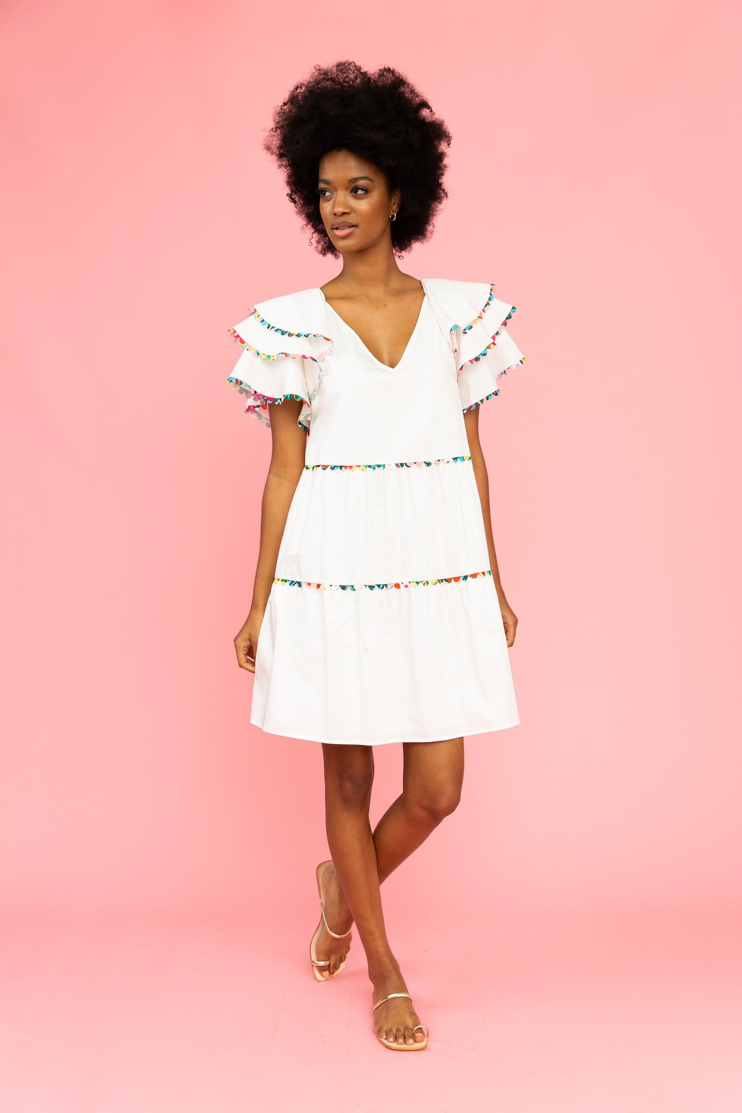 White v-neck dress with colorful trim and ruffled sleeves