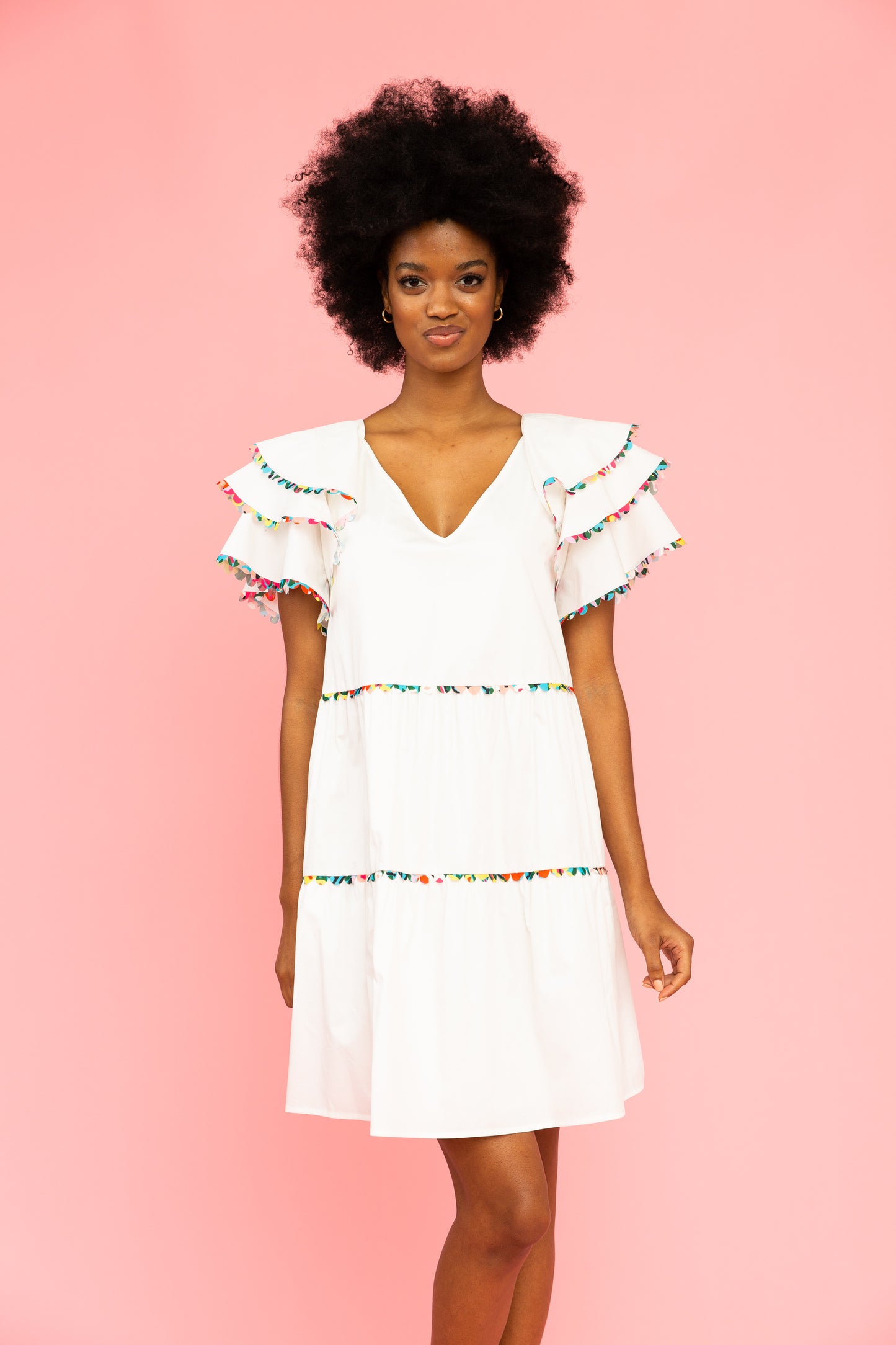 White v-neck dress with colorful trim and ruffled sleeves
