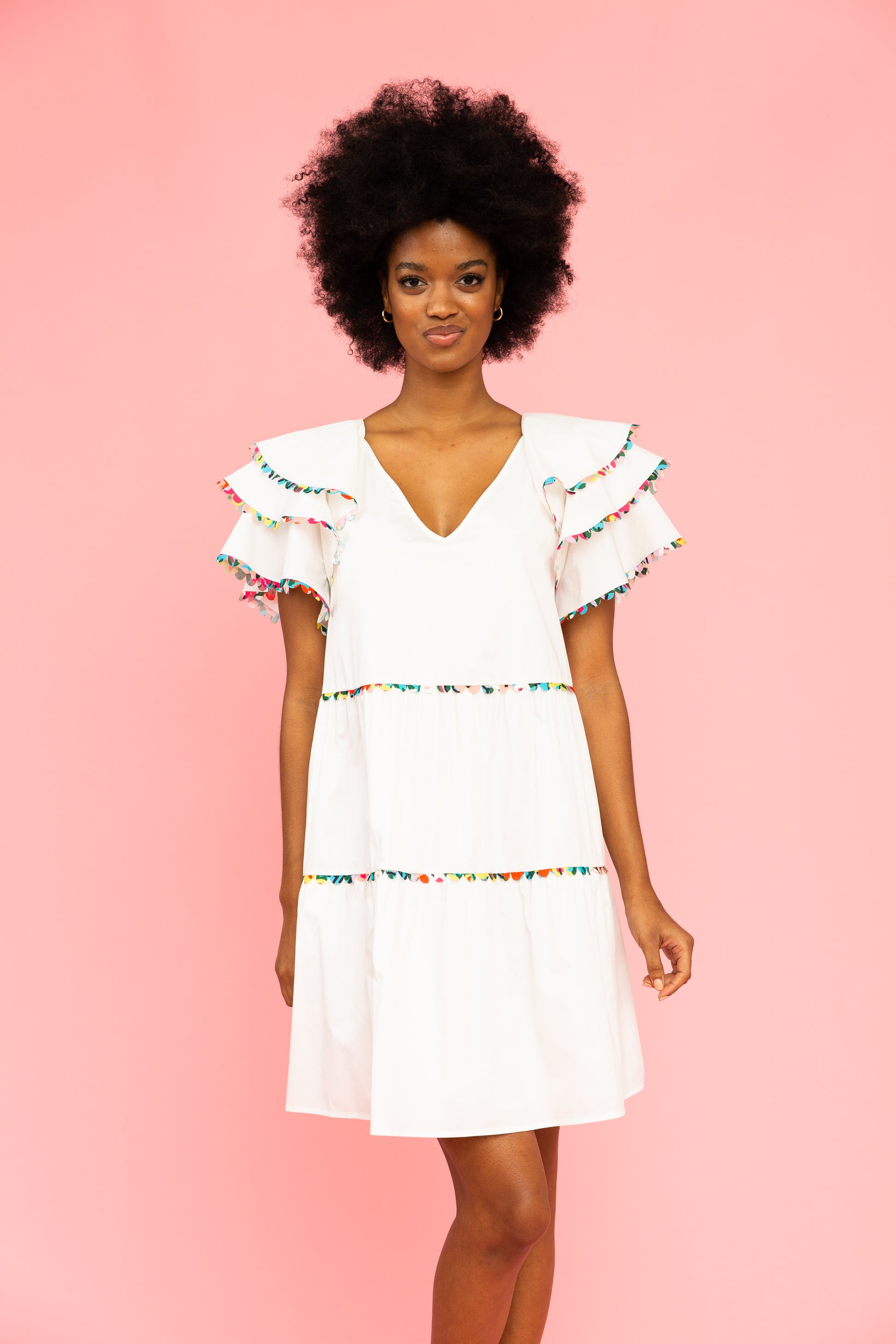 White v-neck dress with colorful trim and ruffled sleeves