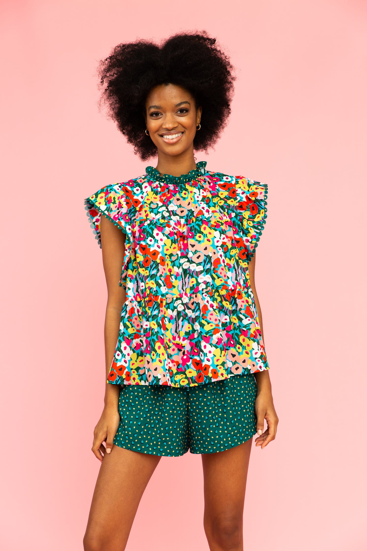 Brightly colored floral top with tiered silhouette and green patterned shorts