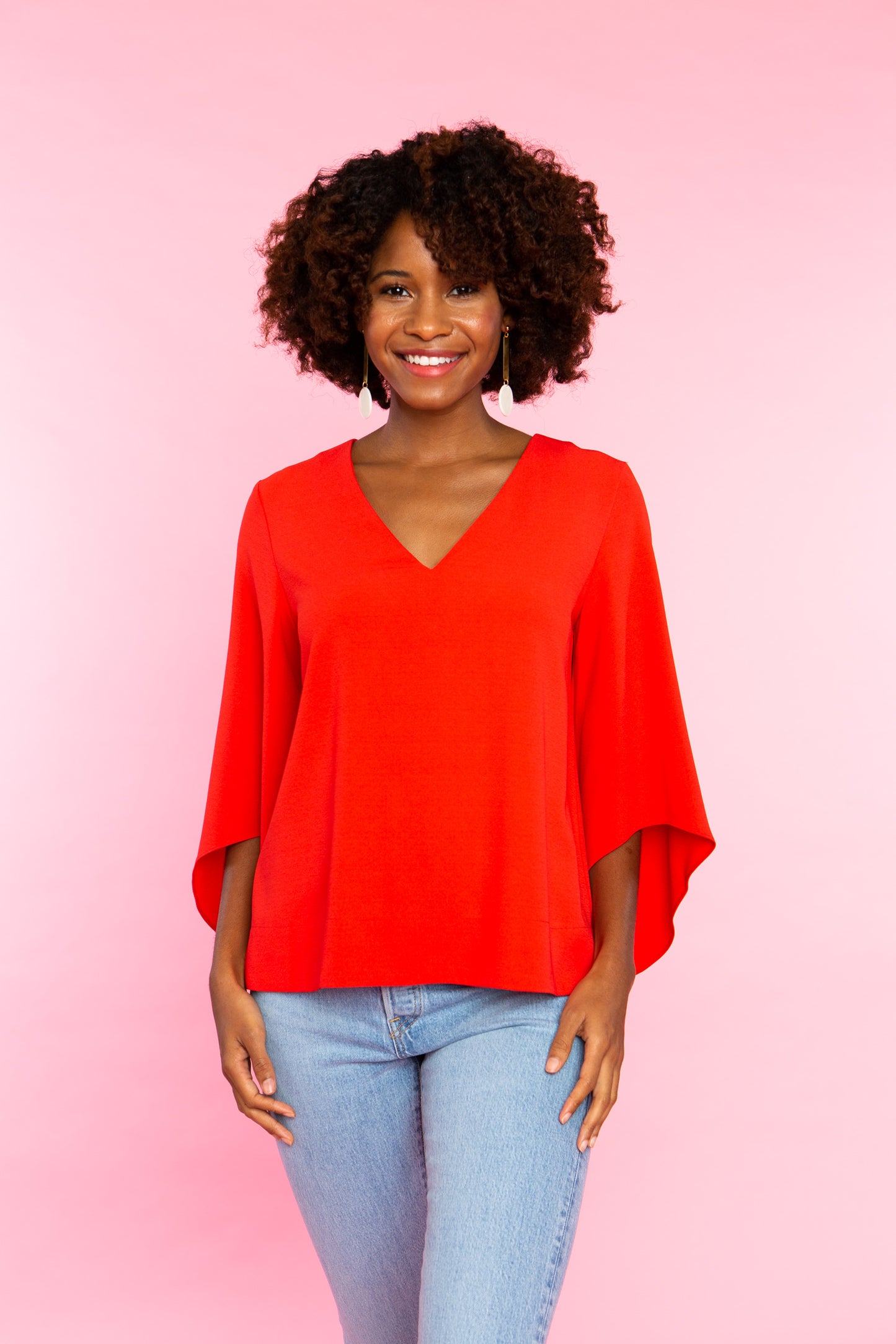 black woman wearing red v neck shirt with wide sleeves