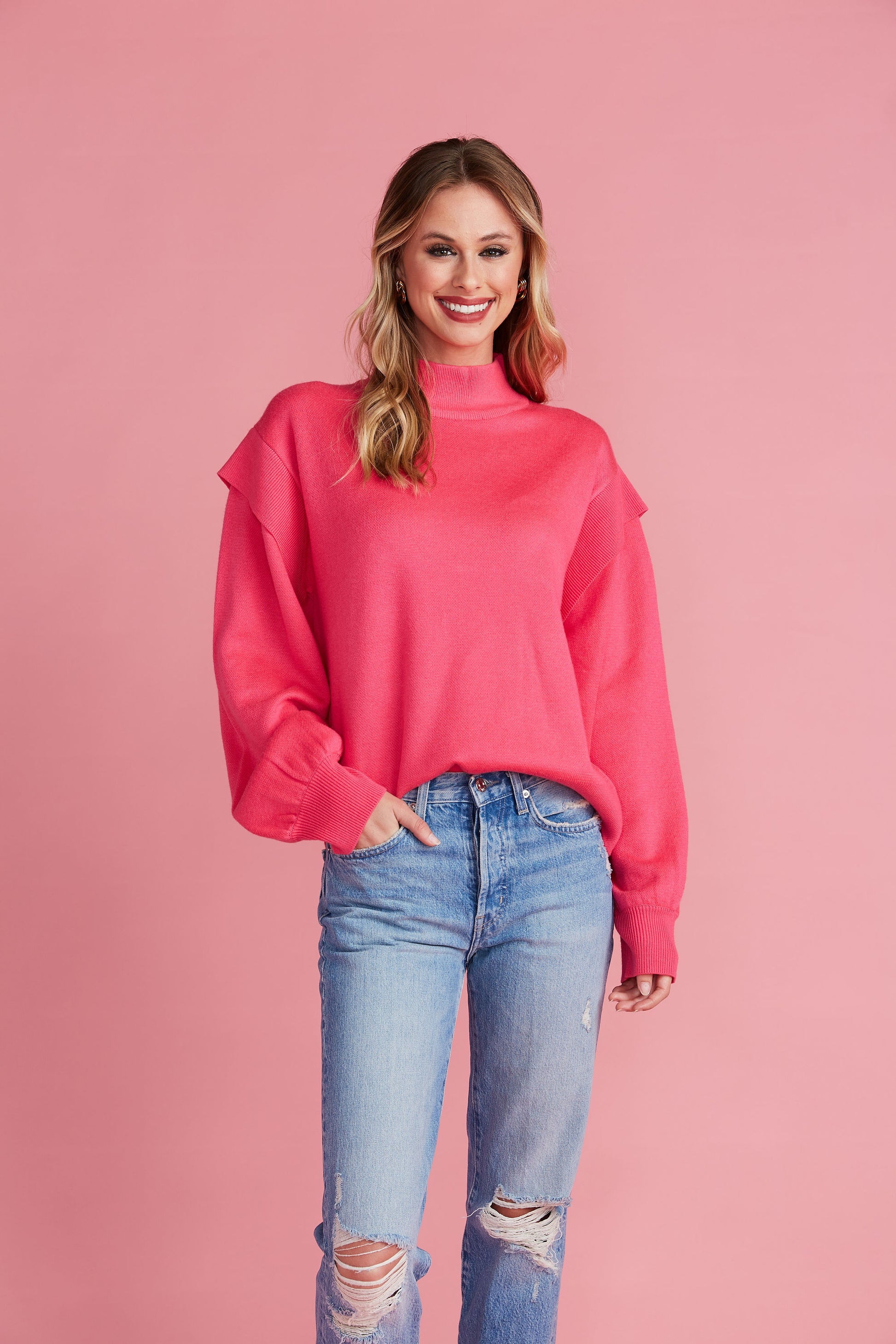 Woman in bright pink mock neck sweater