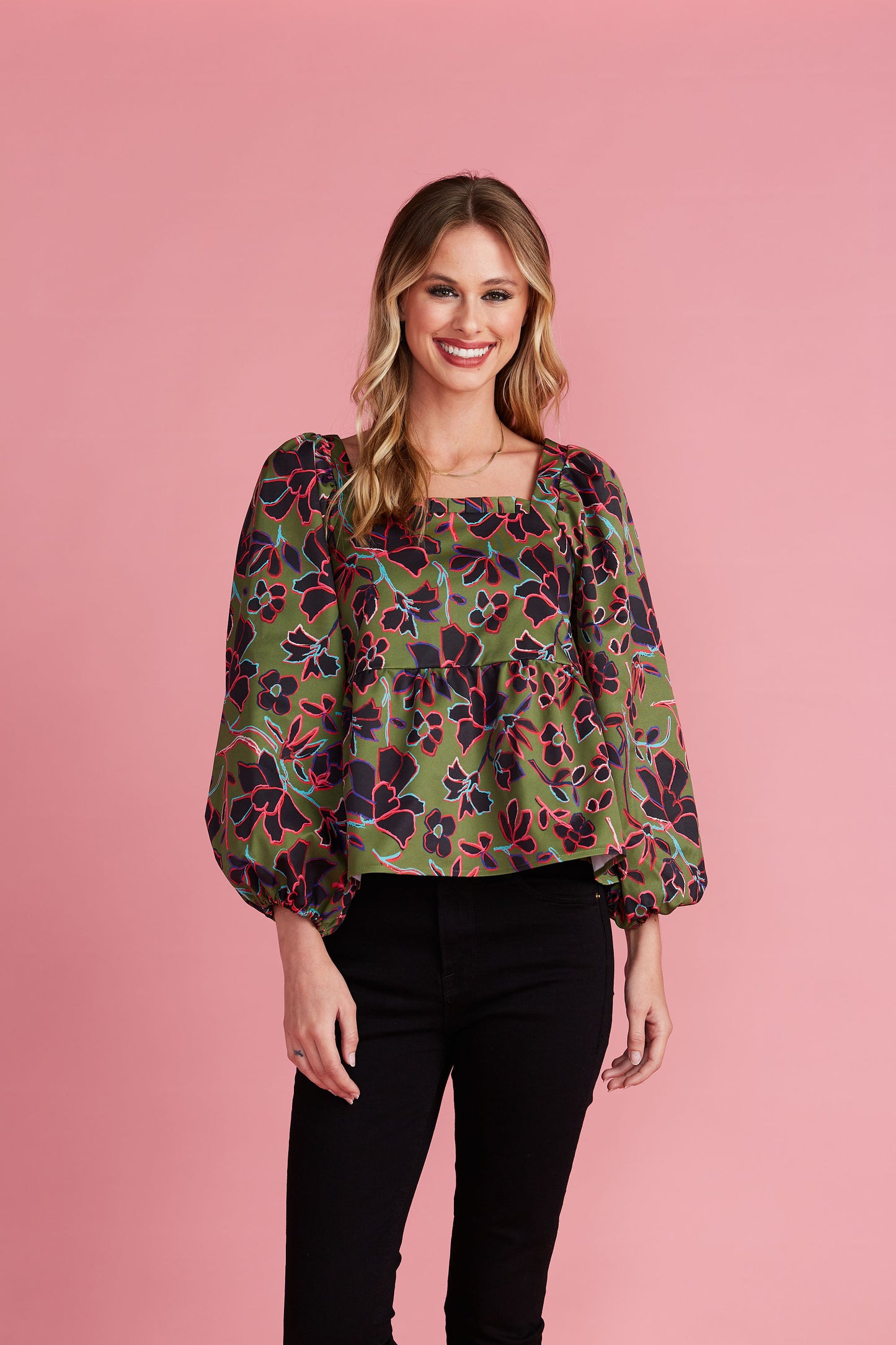 Woman in green square neck blouse with floral pattern and voluminous sleeves